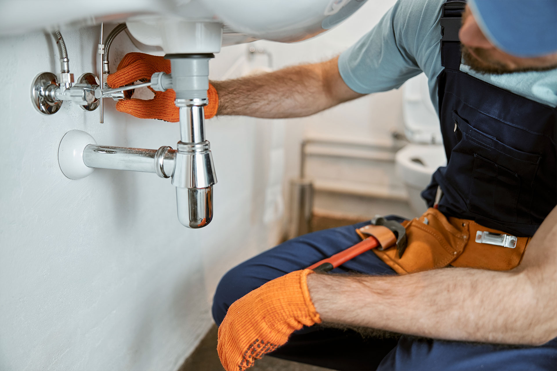 male-plumber-hands-repairing-pipe-under-sink-2022-03-24-16-02-46-T8E3TZP.jpg