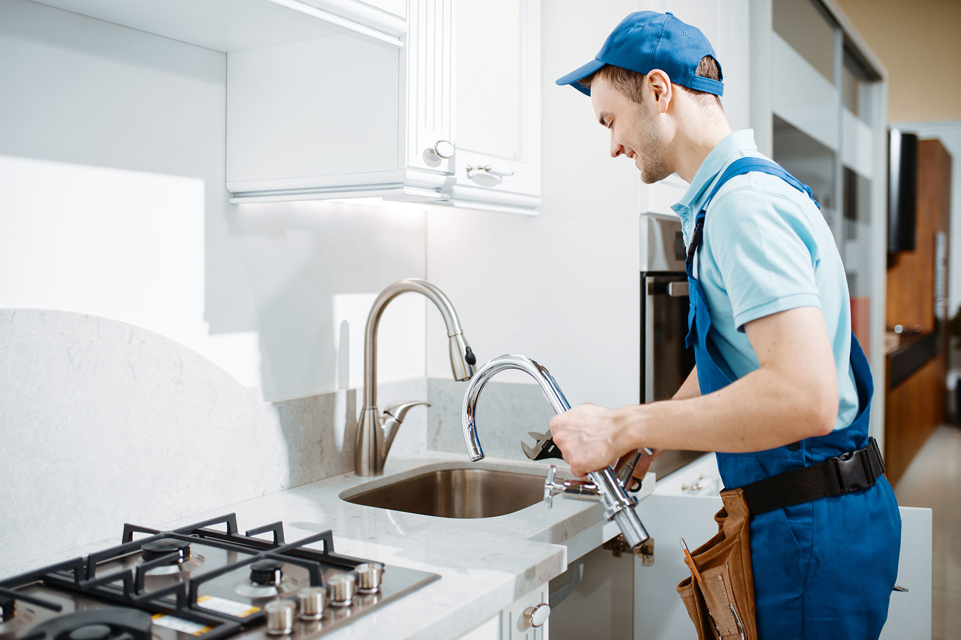 plumber-in-uniform-changes-faucet-in-the-kitchen-2021-08-28-02-49-27-8YY2ZB5.jpg