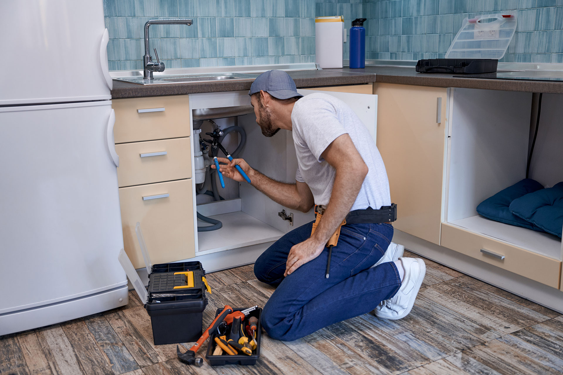 young-caucasian-male-worker-fixing-tubes-under-kit-2022-02-22-05-13-40-HLW4XHF.jpg